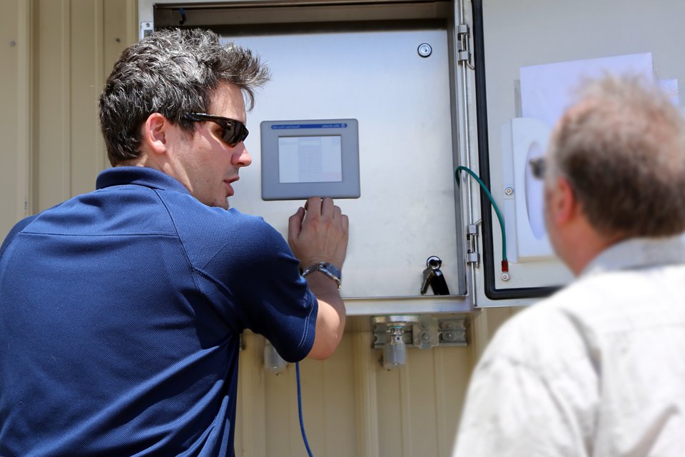 An EleMech engineer on field service trains a client on the use of a new station.